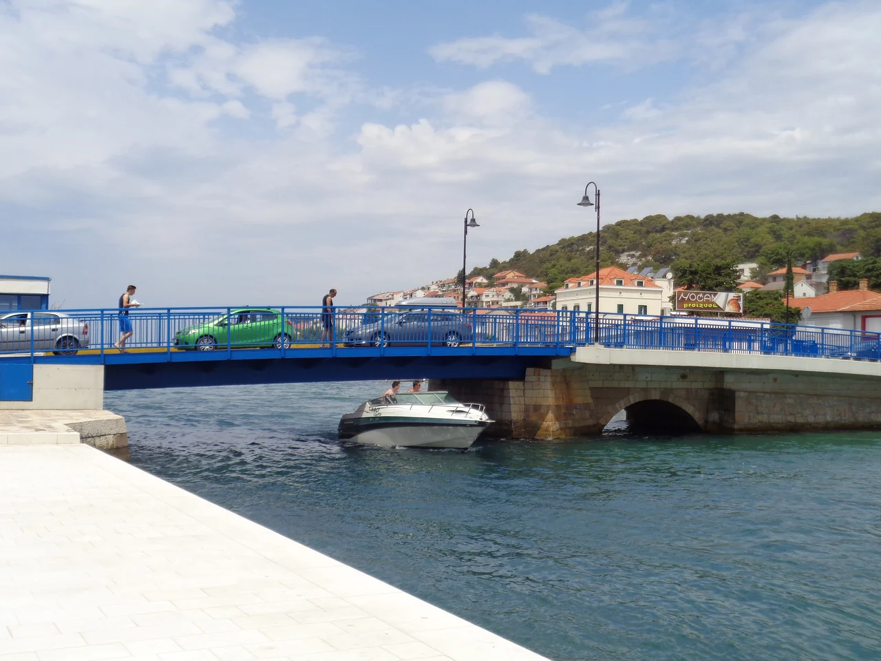 Motoscafo sotto il ponte mobile blu di Tisno