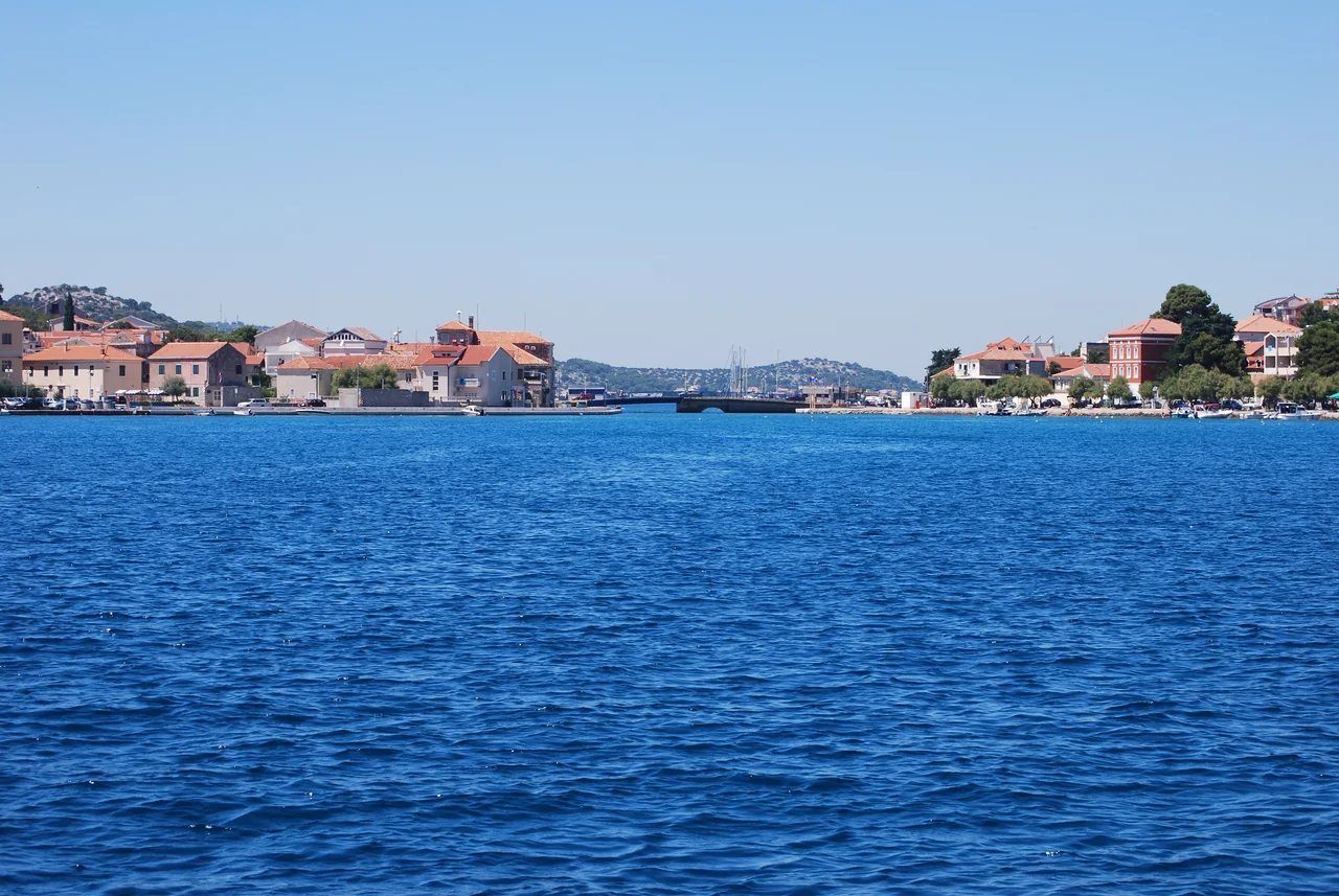 Le due rive di Tisno e il ponte sul mare blu intenso